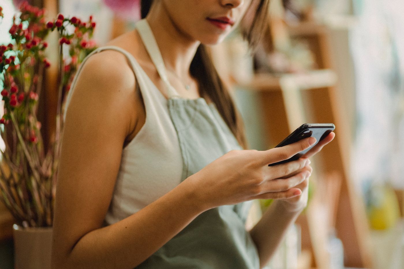 Emprendedora usando su teléfono para administrar su negocio